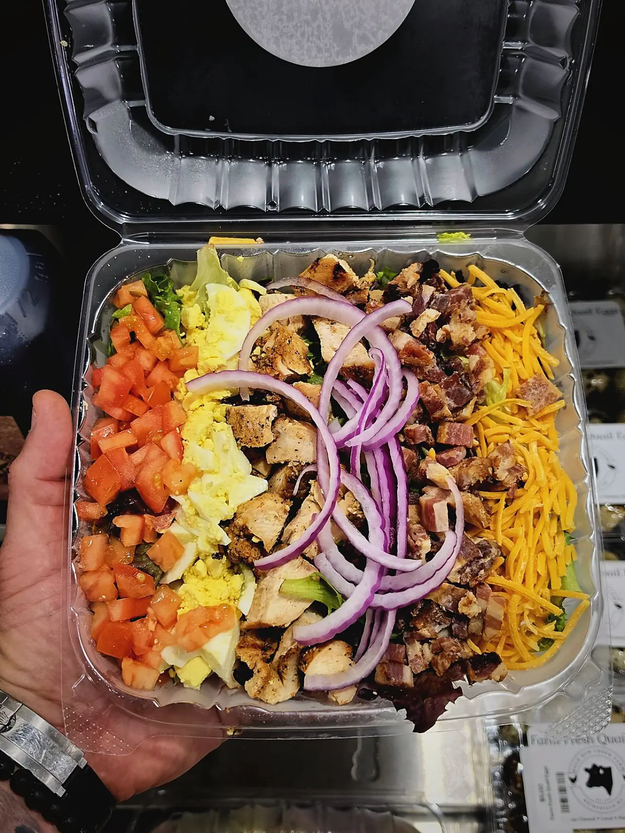 A loaded cobb salad boxed to go