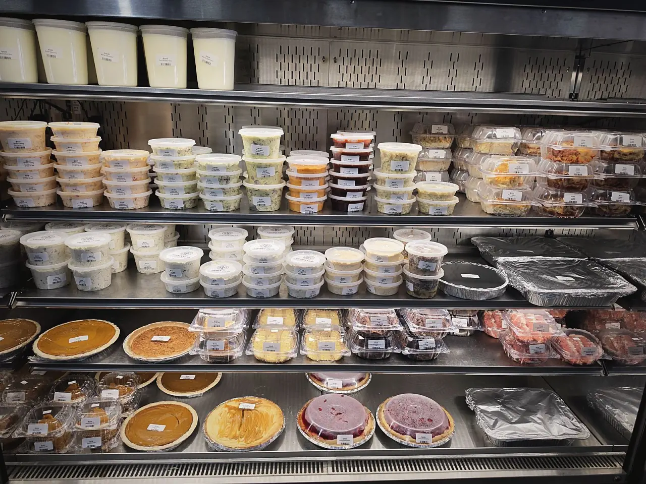 The cold case stocked with whole pies and house desserts