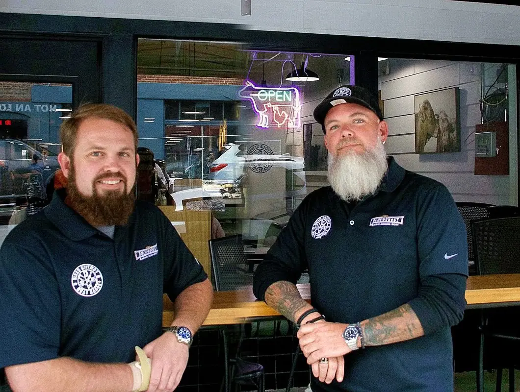 Tommy Conner and Phillip Decker at the counter under the neon OPEN sign