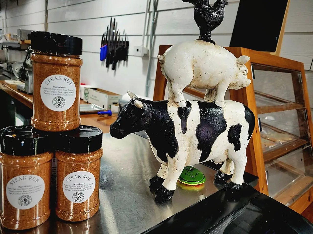 Jars of house steak rub beside the cow figurine at the register